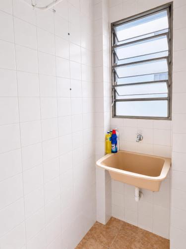 a bathroom with a sink and a window at Apartamento Residencial Alice in Uberaba