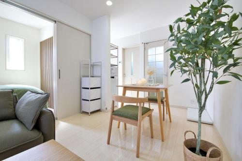 a living room with a table and a potted plant at Green Gables A棟 105 in Toyama