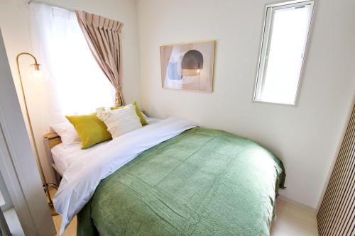 a bed in a room with a window at Green Gables A棟 105 in Toyama