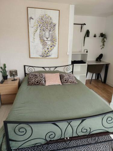 a bedroom with a bed with a green comforter at Chambre jungle in Calais