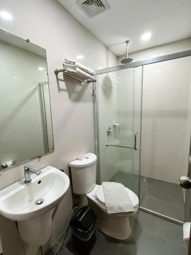 ein Badezimmer mit Dusche, Toilette und Waschbecken in der Unterkunft Mango Suites in Tuguegarao City