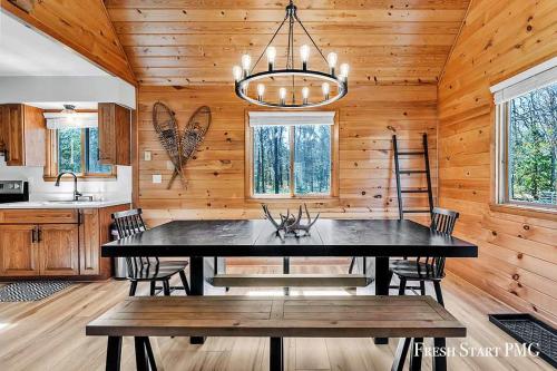 a dining room with a table and a chandelier at Cabin in Wellston in Wellston