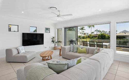 a living room with a couch and a tv at Oasis By Khove - Broadbeach Waters in Gold Coast