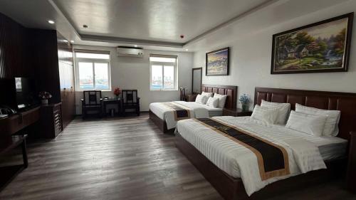 a hotel room with two beds and a television at Văn Lâm Hotel in Ðình Dù