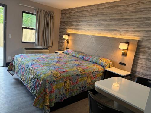 a hotel room with a bed and a table at Midway Motel in Patchogue