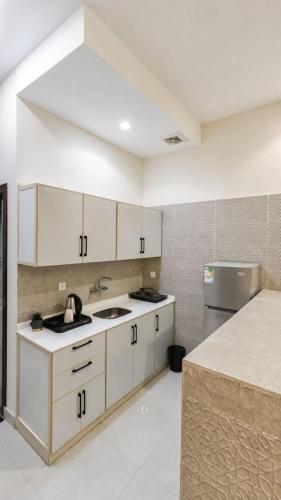 a kitchen with white cabinets and a sink and a refrigerator at وحدات سكنية الشفا in Khamis Mushayt