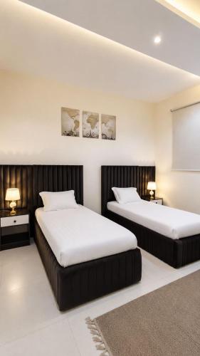 two beds in a room with white walls at وحدات سكنية الشفا in Khamis Mushayt