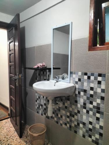 a bathroom with a sink and a mirror at Pong Elak 'Guest House in Rantepao