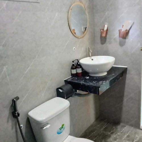 a bathroom with a white toilet and a sink at BONNIE HOMESTAY Mui Ne in Mui Ne