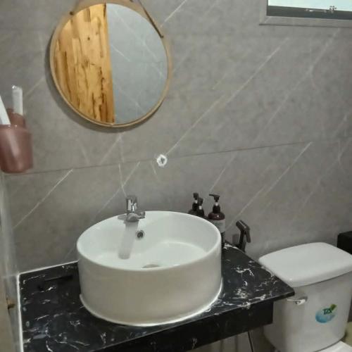 a bathroom with a sink and a mirror and a toilet at BONNIE HOMESTAY Mui Ne in Mui Ne