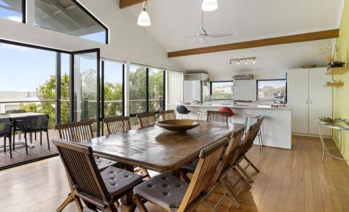a kitchen and dining room with a wooden table and chairs at Ocean Blue View in Capel