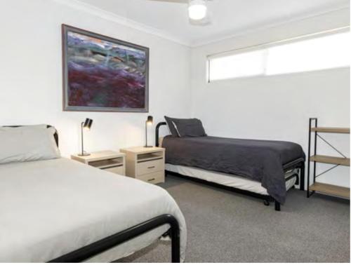 a bedroom with two beds and a painting on the wall at Ocean Blue View in Capel