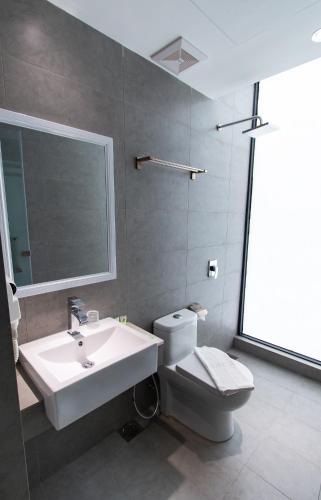 a bathroom with a sink and a toilet and a mirror at Hotel 99 Sepang KLIA & KLIA2 in Sepang