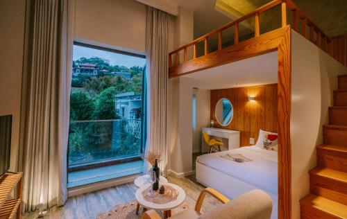 a bedroom with a bunk bed and a large window at Hanoi Amsterdam Art Studio in Da Lat