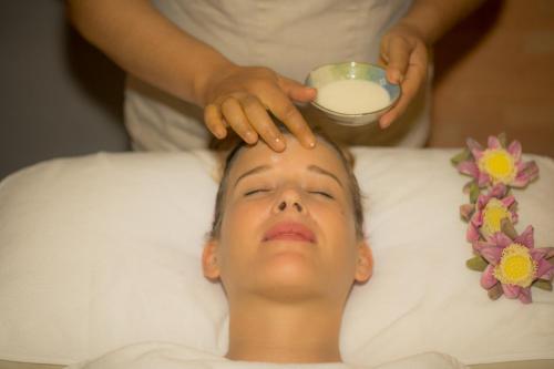 a man laying in a bed getting a head massage at Golden Temple Retreat in Siem Reap