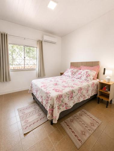 a bedroom with a large bed and a window at AmazHost - Casa Rosa com Split, Wi-Fi 700 Mb e Água Quente in Belém