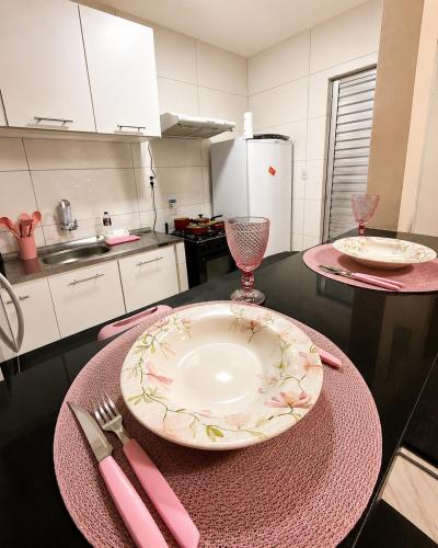 a table with a plate and a fork and knife at AmazHost - Casa Rosa com Split, Wi-Fi 700 Mb e Água Quente in Belém
