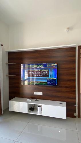a flat screen tv on a wooden wall at Vayangankar House in Belgaum