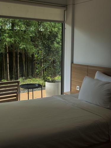 a bedroom with a bed and a large window at Bungalow Homes in Bandung