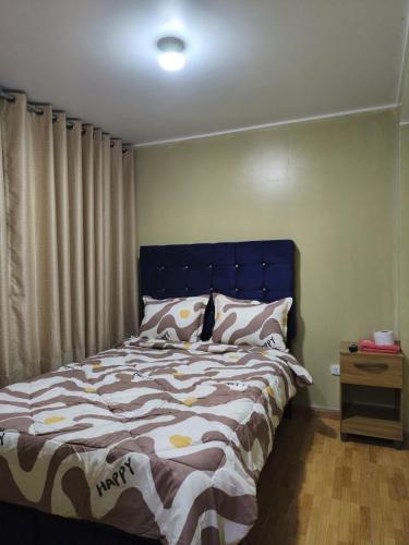 a bed with a blue headboard in a bedroom at Hostal jm in Huancayo