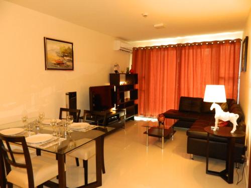 a living room with a dining table and a living room with a couch at Neo Condo by Jean in Jomtien Beach