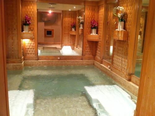 ein großer Pool mit Wasser in einem Zimmer mit Spiegeln in der Unterkunft Issham Hotel in Dschidda