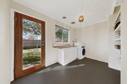 a kitchen with a sink and a washing machine at Charming Guesthouse in Kyneton in Kyneton