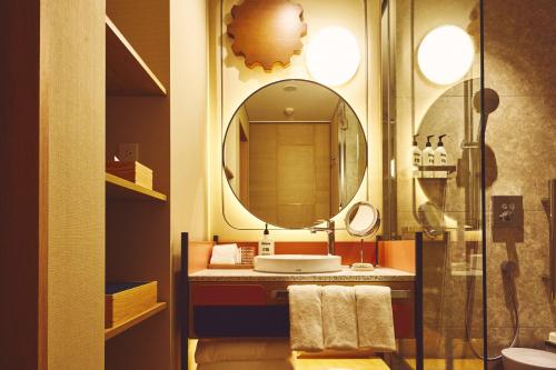 a bathroom with a sink and a mirror at Hotel Indigo Inuyama Urakuen Garden by IHG in Inuyama