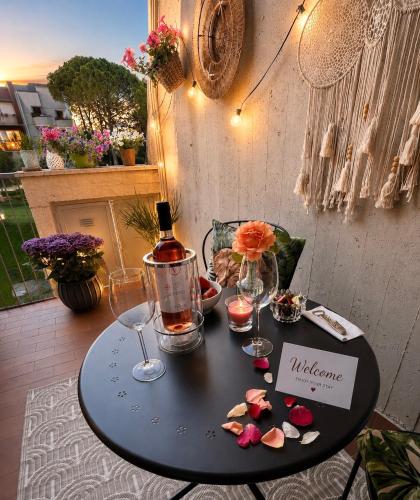 a black table with a bottle of wine and glasses at Aloha Pool Apartment - Free Parking - Sirmione in Desenzano del Garda