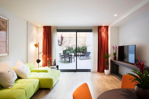 a living room with a yellow couch and a television at Cosmo Apartments Passeig de Gràcia in Barcelona