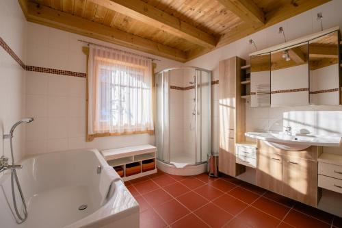 a bathroom with a tub and a shower and a sink at Ferienwohnungen Schwabhof in Kleinarl