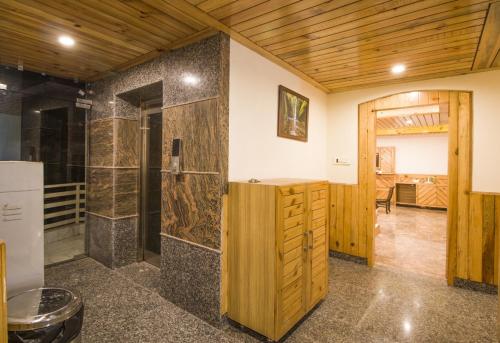 a bathroom with a shower and a wooden ceiling at Marina Group of hotel Naddi mountain view -cricket stadium 9 km-Mcleodganj 2 km- Bhagsunag 4 in Dharamshala