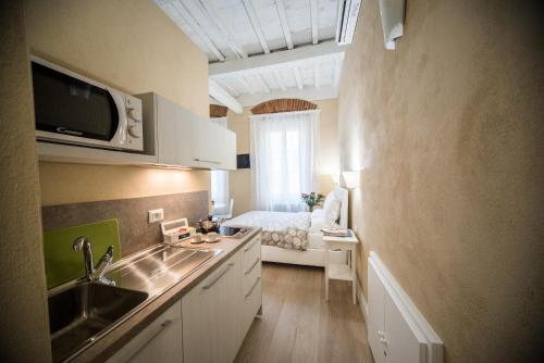 a kitchen with a sink and a bed in a room at Apartments Lorenzo&Lorenzo in Florence