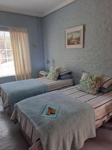 a hotel room with two beds and a book on top at Voni's Cottage in Vredendal