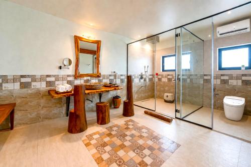 a bathroom with a glass shower and a toilet at Resort Terra Paraiso Goa - A Beach Property in Calangute