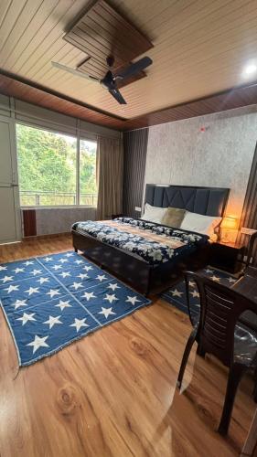 a bedroom with a bed with a blue rug and a ceiling at Hideout Bir in Bīr
