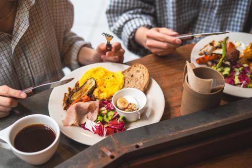 two people sitting at a table with a plate of food at CITAN Hostel in Tokyo