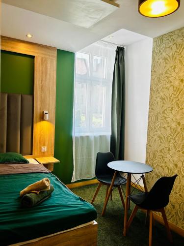 a bedroom with a bed and a table and a window at Stacja Jeżyce Pokój #B in Poznań