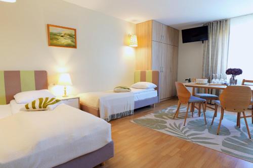 ein Hotelzimmer mit zwei Betten und einem Tisch in der Unterkunft Irbēni in Brivkalni