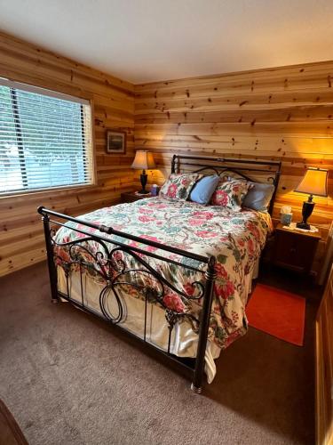 a bedroom with a bed with a wooden wall at Beautiful Sierra Mountain Cabin in Springville