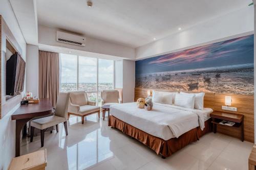 a hotel room with a bed with a teddy bear on it at Ascent Premiere Hotel and Convention in Malang