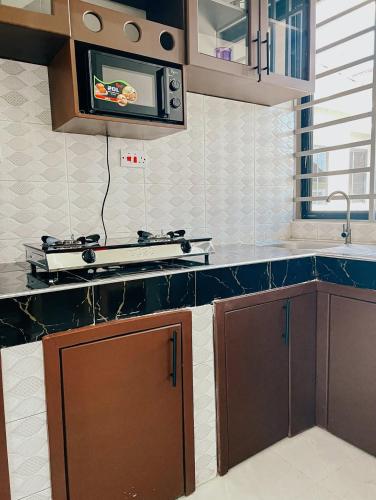 a kitchen with a sink and a microwave at SINDOM APARTMENTS Dodoma in Dodoma