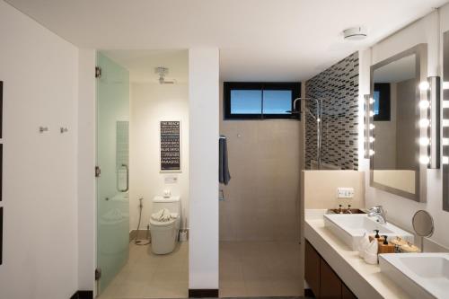 a bathroom with two sinks and a shower and a toilet at The Cosy New Appartement Fisherman in Bophut