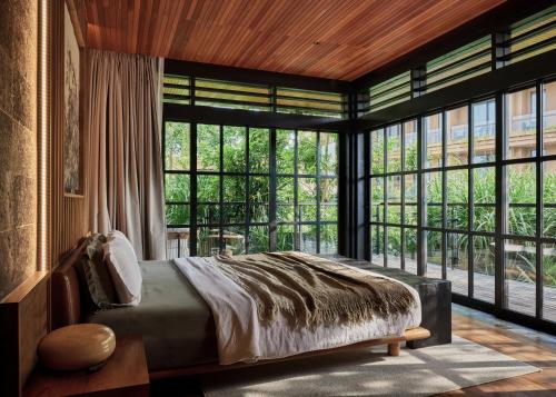 a bedroom with a bed and large windows at Villa Suki in Canggu