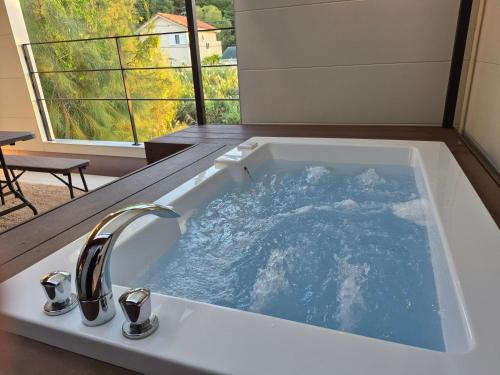 a bath tub filled with water with a sink at Villa YUKUI in Onna