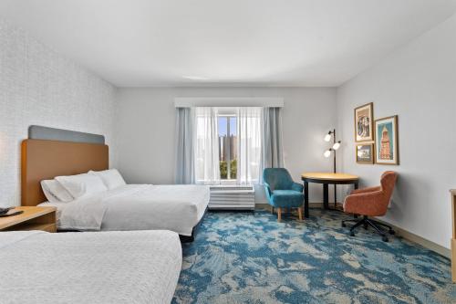 a hotel room with two beds and a table and chairs at Hampton Inn By Hilton Wharton in Wharton
