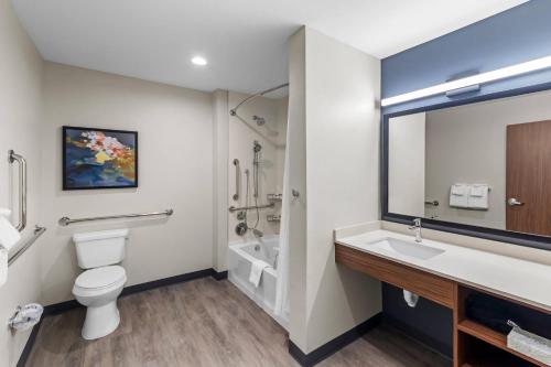 a bathroom with a toilet and a sink and a mirror at Everhome Suites Georgetown - Austin in Georgetown