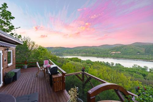 a house with a deck with a view of a river at Sherpa Pihenőház in Nagymaros