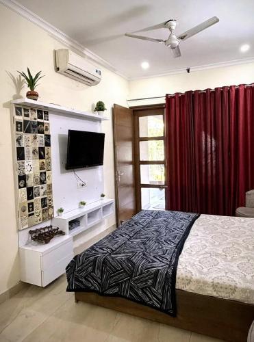 a bedroom with a bed and a flat screen tv at Calm Corner in Panchkula