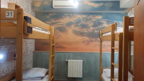 a room with bunk beds and a mural of a sunset at Envoy Hostel & Tours in Yerevan